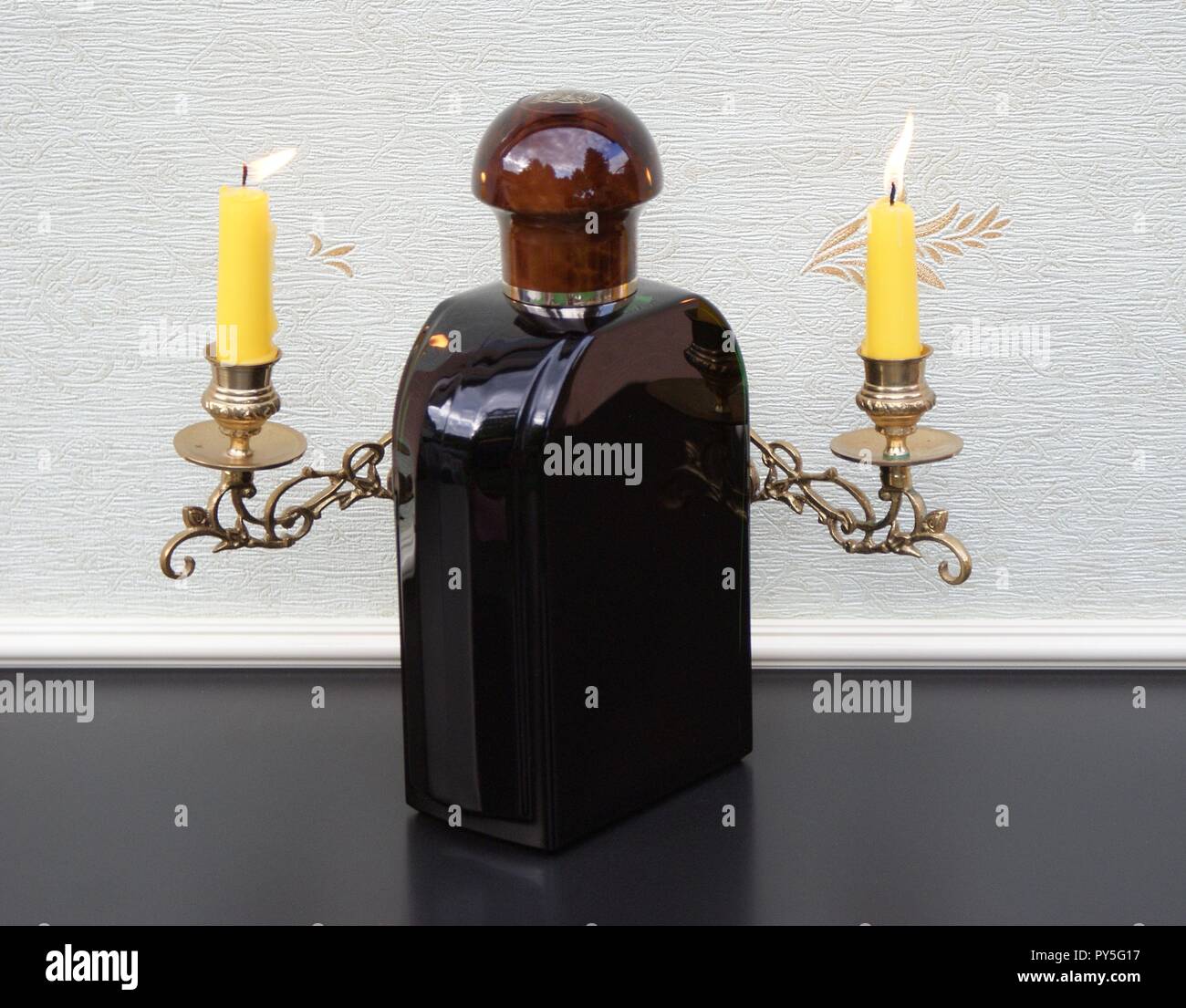 Jaguar for Men, Eau de toilette, un grand flacon de parfum devant un piano avec bougies candélabre brillant Banque D'Images