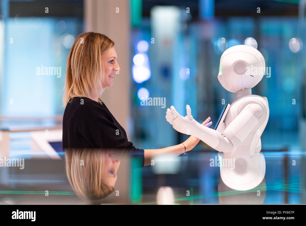 Paderborn, Allemagne. 26Th Oct, 2018. Curator Judith Spickermann s'élève face à un robot de service appelé le poivre dans l'exposition 'l'intelligence artificielle et la robotique' au Heinz Nixdorf MuseumsForum. Le poivre est utilisé pour les interactions sociales, en ce moment surtout en salles de vente et dans le secteur des soins. Du 27 octobre, le Heinz Nixdorf MuseumsForum présentera les derniers développements de l'intelligence artificielle et de la robotique sur 500 mètres carrés. Credit : Guido Kirchner/dpa/Alamy Live News Banque D'Images