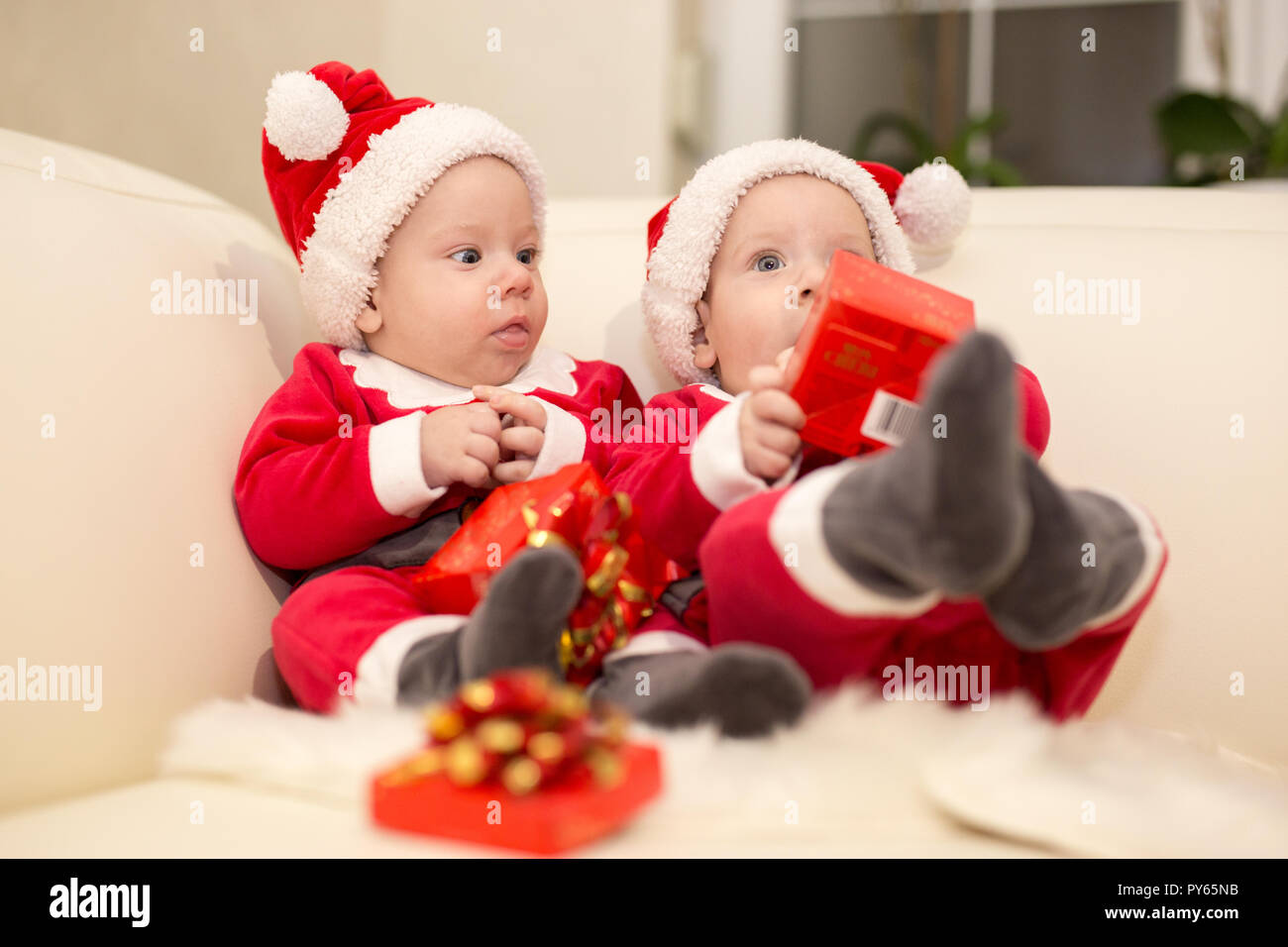 Mignon bébé frères et sœurs se présente pour Noël avec santa hats Banque D'Images