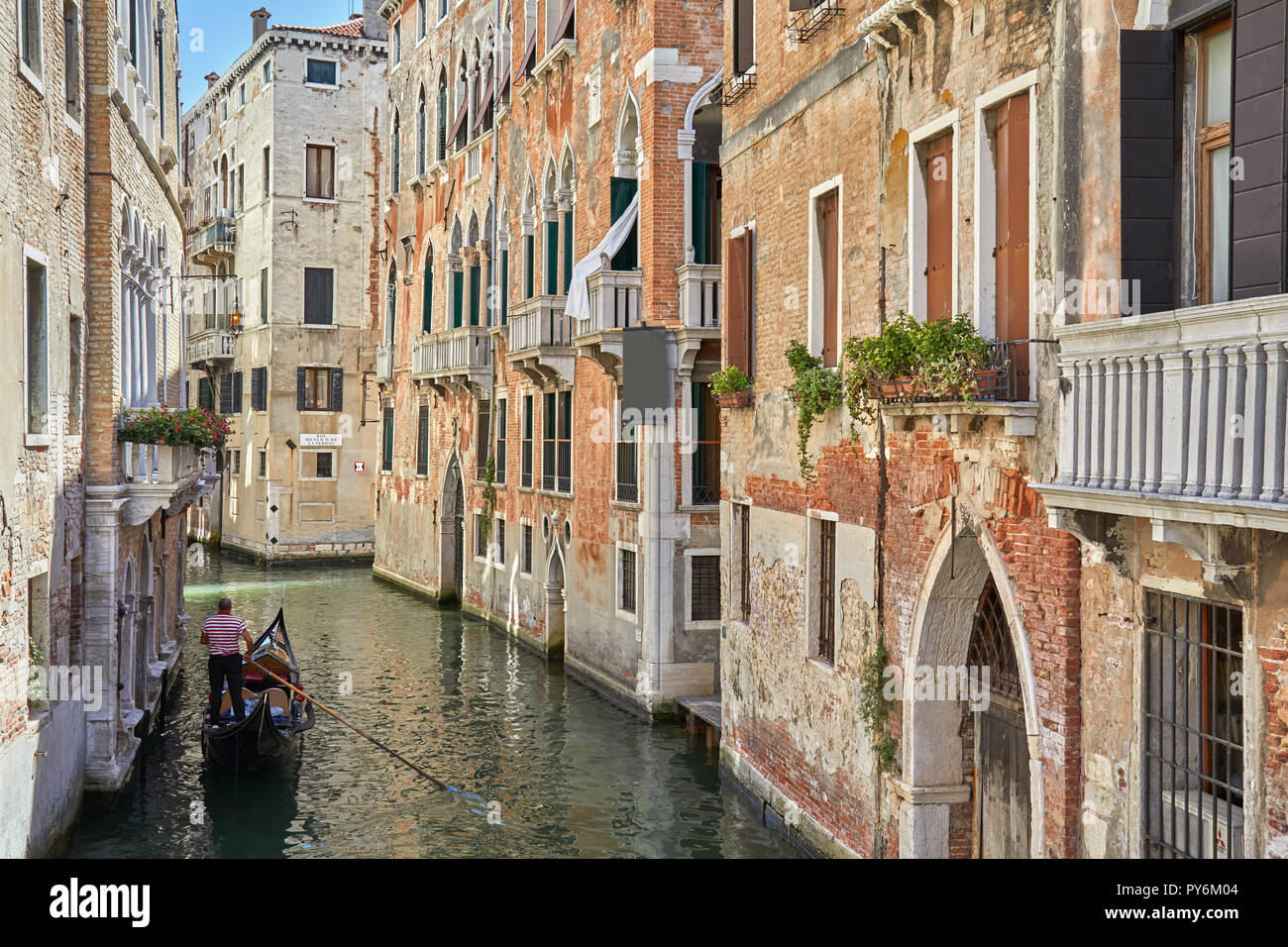 Venise, Italie - 13 août 2017 : Canal avec gondola et briques anciennes mur dans une journée ensoleillée, scène tranquille de Venise, Italie Banque D'Images