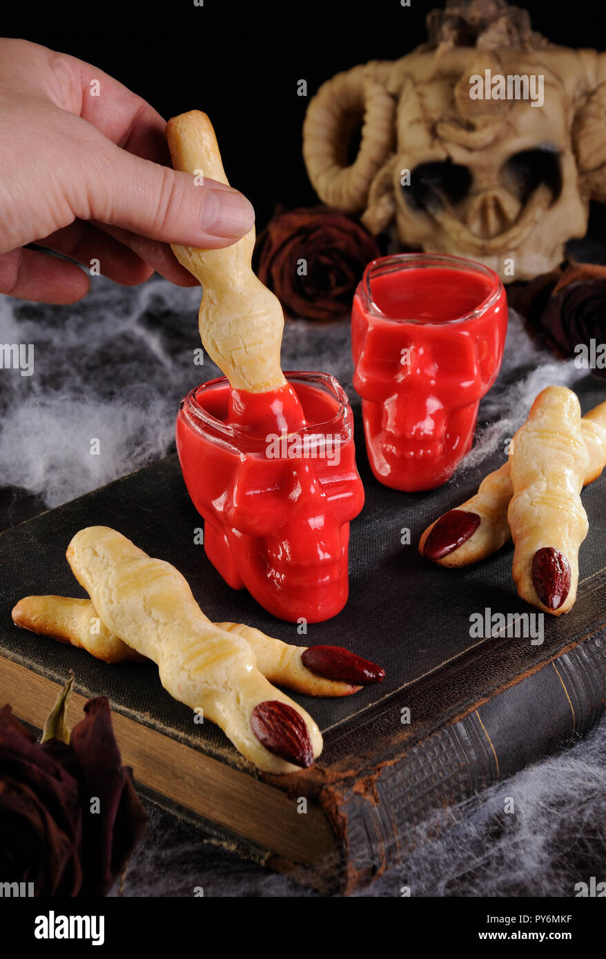 Sablés croquants trempette dans la forme de doigts de sorcière dans du chocolat chaud 'Red Velvet'.C'est tout simplement délicieux. Banque D'Images