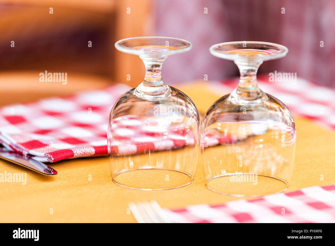 Gros plan macro de deux verres à l'envers sur verre table de restaurant à  Rome, Italie, l'italien à l'extérieur dans un style traditionnel café de la  rue de la chec rouge et