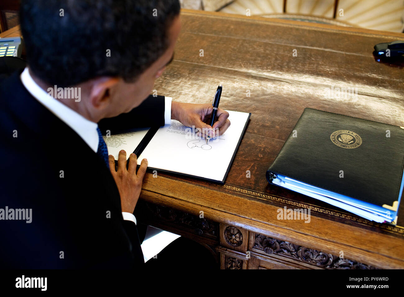 Le président Barack Obama écrit à son bureau dans le bureau ovale 3/3/09. Photo Officiel de la Maison Blanche par Pete Souza Banque D'Images