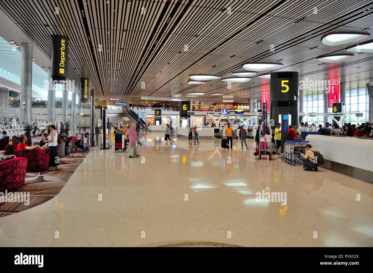 Les passagers au terminal de l'aéroport Changi de Singapour 4 départs auto compteur aire d'enregistrement Banque D'Images