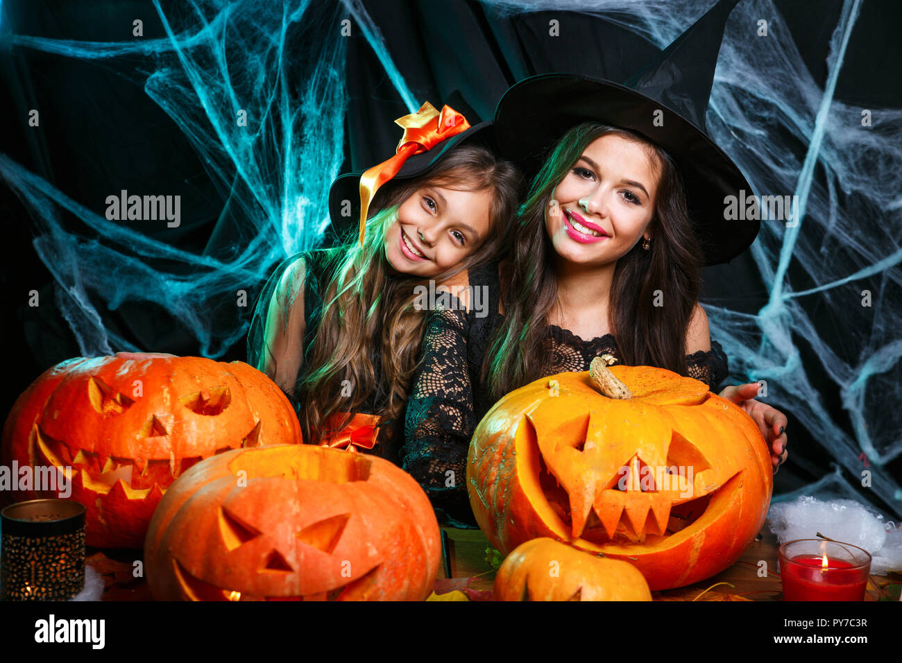 Famille heureuse de préparer pour l'Halloween. Jeune maman et sa fille en costume de sorcière célébrer les jours fériés. Banque D'Images