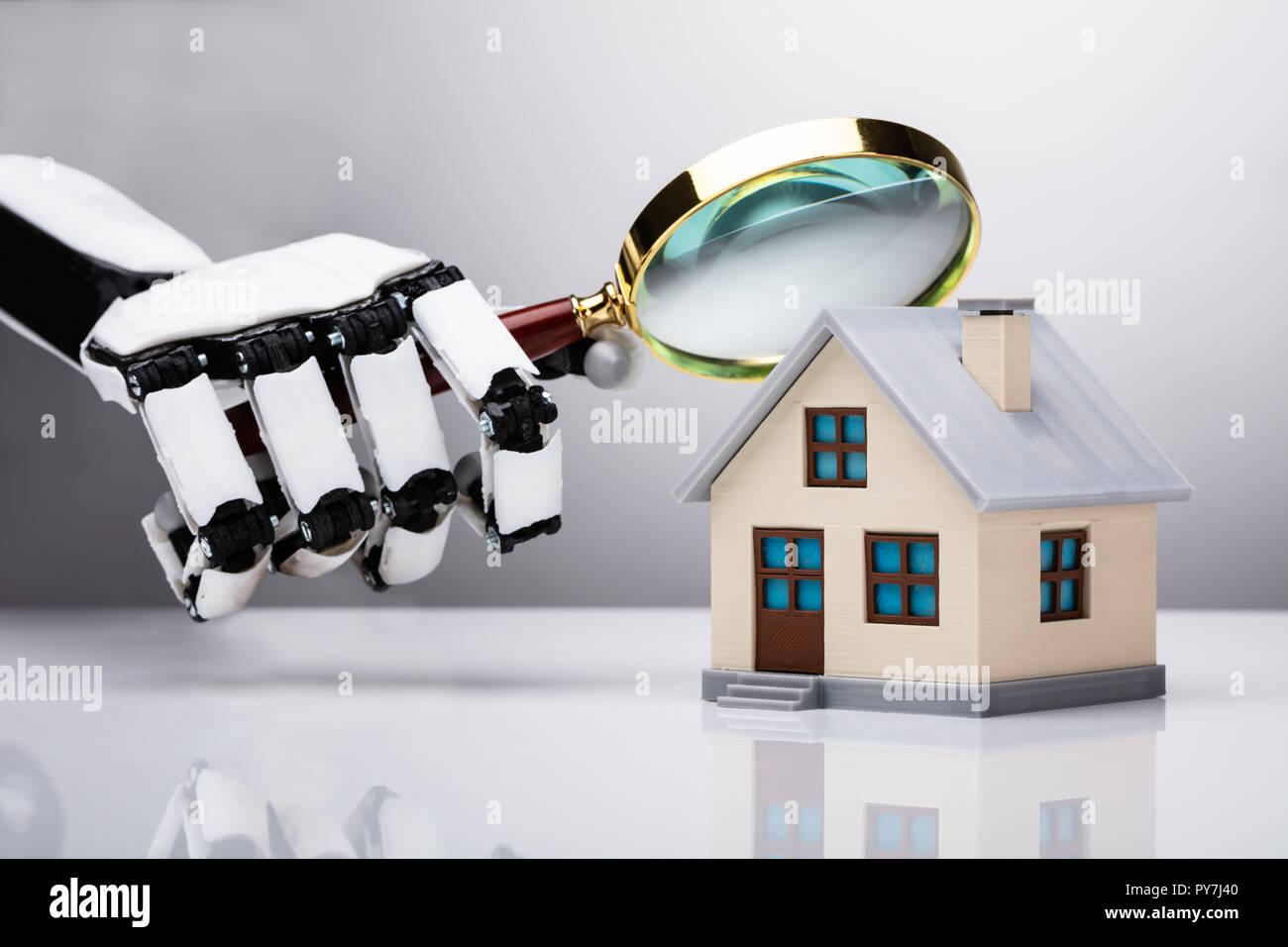 L'examen de la main robotique House Model With Magnifying Glass Banque D'Images