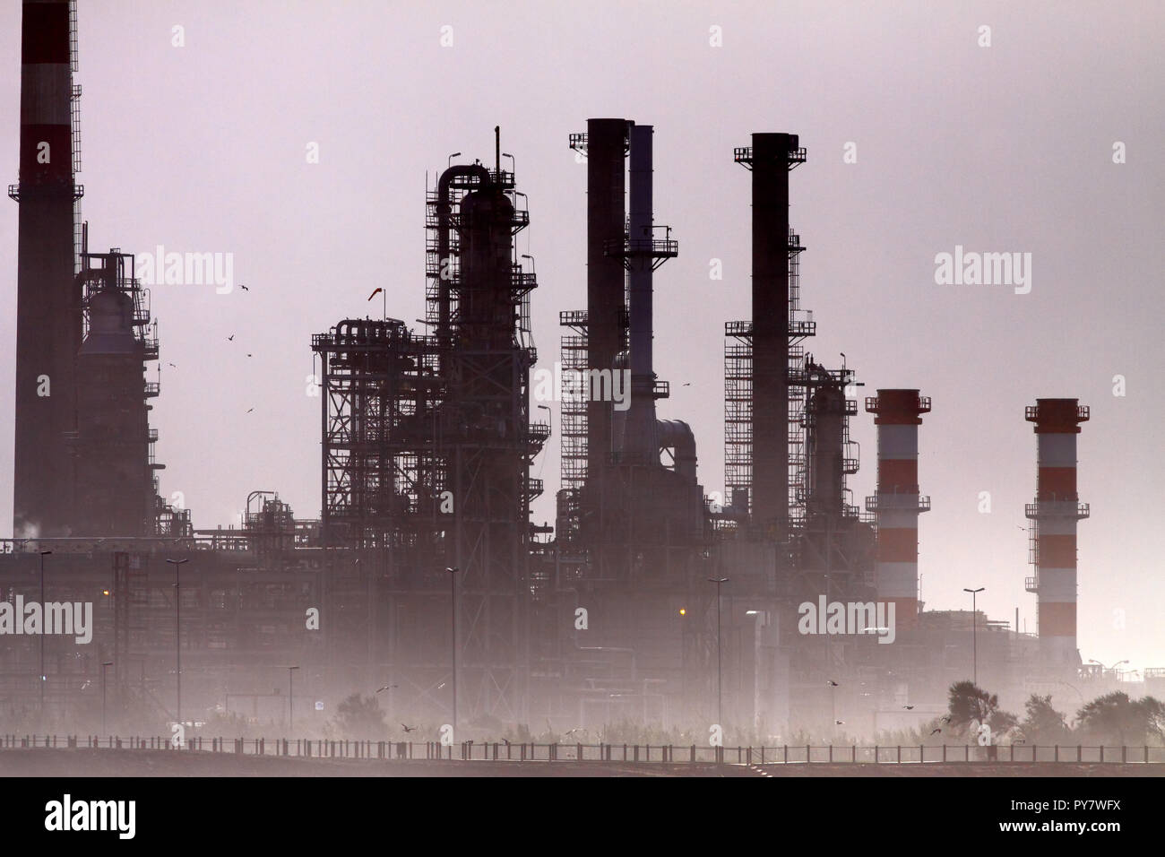 Silhouette de partie d'une grande raffinerie de pétrole avec un éclairage intéressant voir le smog Banque D'Images