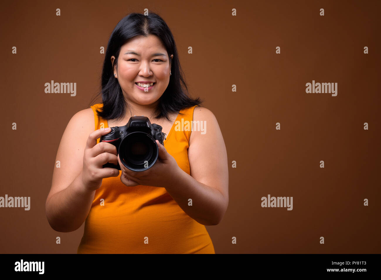Belle femme asiatique de l'embonpoint heureux souriant photographe Banque D'Images