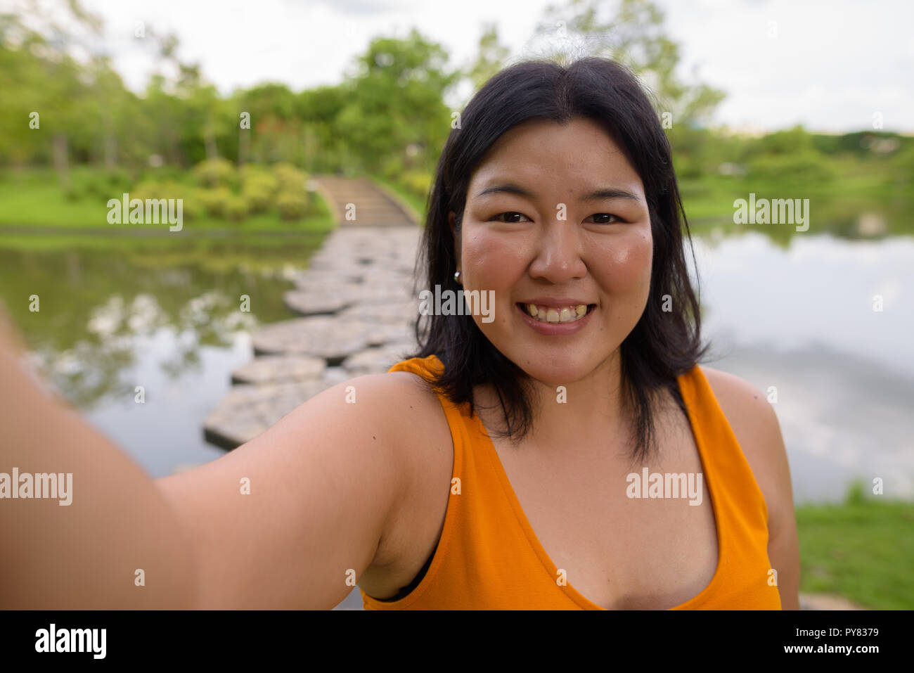 Point de vue personnel de la Belle Femme en surpoids en tenant en selfies park Banque D'Images