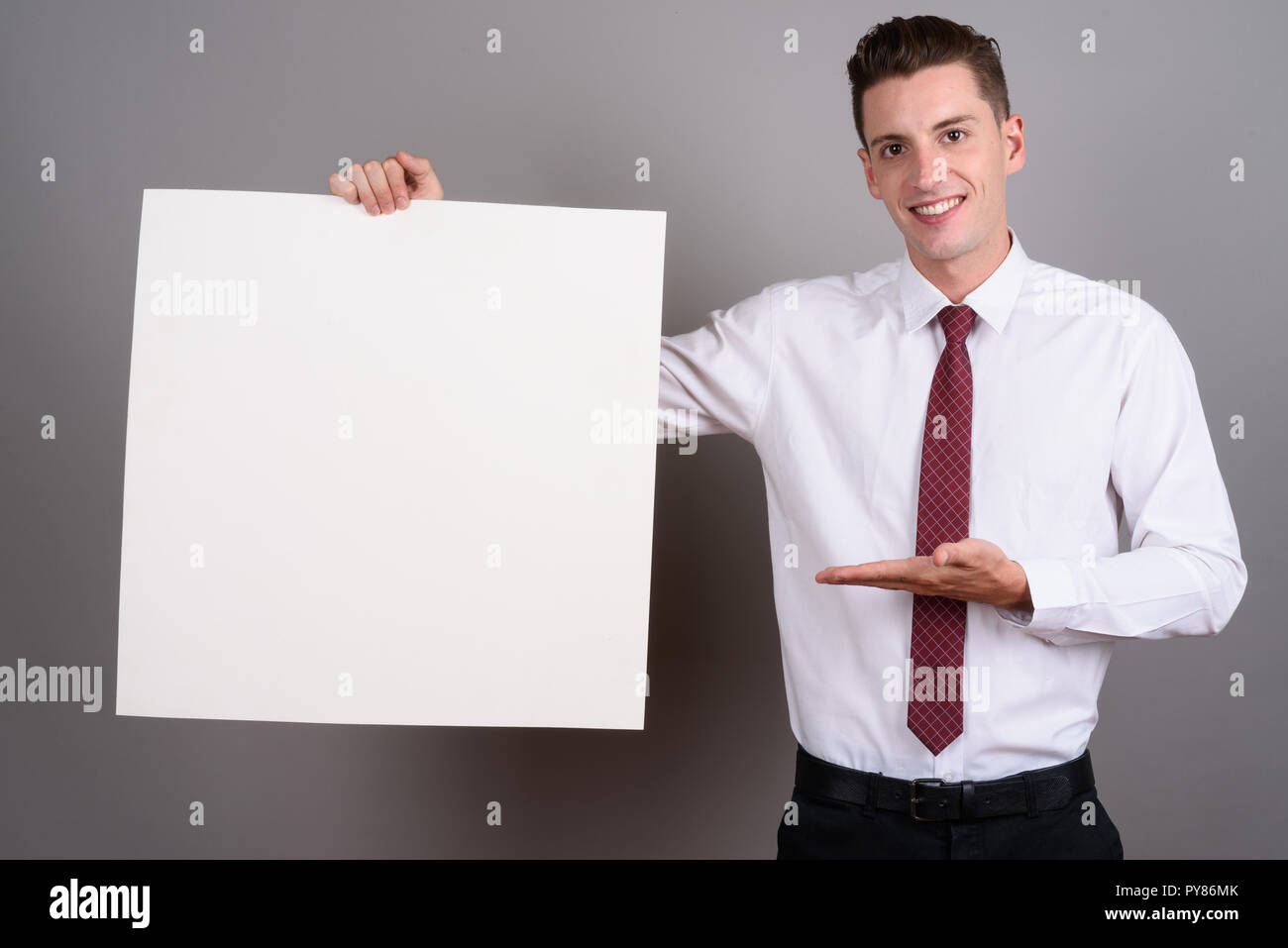 Happy businessman holding empty white board with copy space Banque D'Images