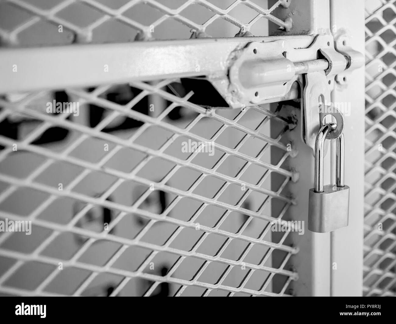 La clé blanche verrouillé sur la poignée sur la clôture métallique porte menant à la salle du système électrique. Banque D'Images