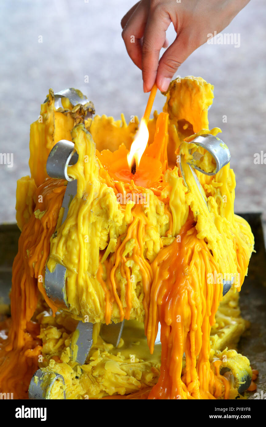 Allumer une petite chandelle par une grosse bougie Banque D'Images