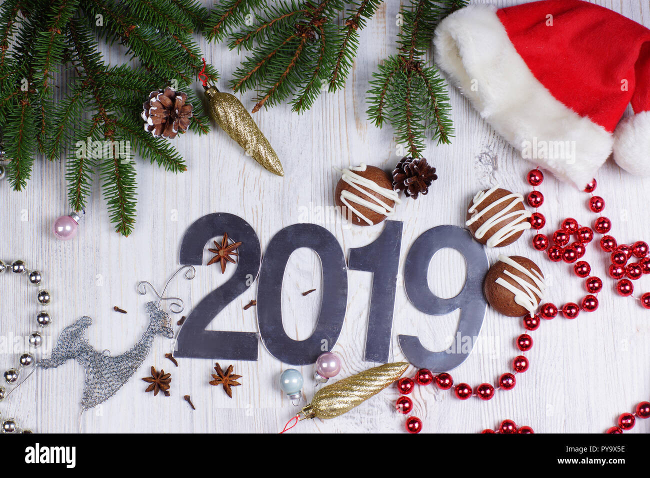Chiffres 2019, les cookies et les décorations de Noël avec un arbre de Noël  avec un bonnet rouge sur fond clair. Nouveau concept de l'année. Carte de  voeux de Noël Photo Stock -