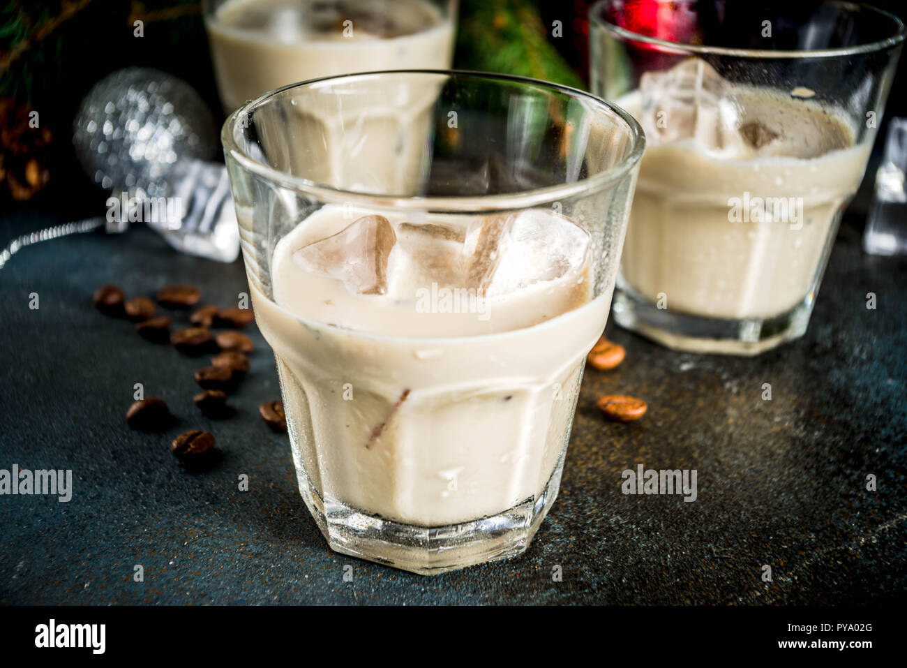 Irish Cream Liqueur cocktail ou boisson traditionnelle de Noël, d'hiver, avec l'arrière-plan foncé rusty branches de sapins de Noël, les grains de café et decorati Banque D'Images