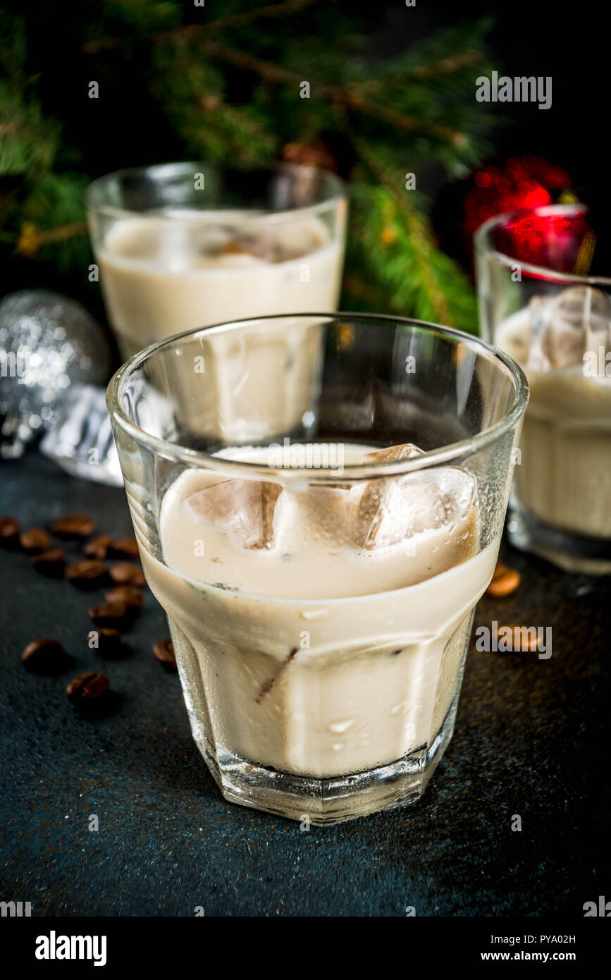 Irish Cream Liqueur cocktail ou boisson traditionnelle de Noël, d'hiver, avec l'arrière-plan foncé rusty branches de sapins de Noël, les grains de café et decorati Banque D'Images