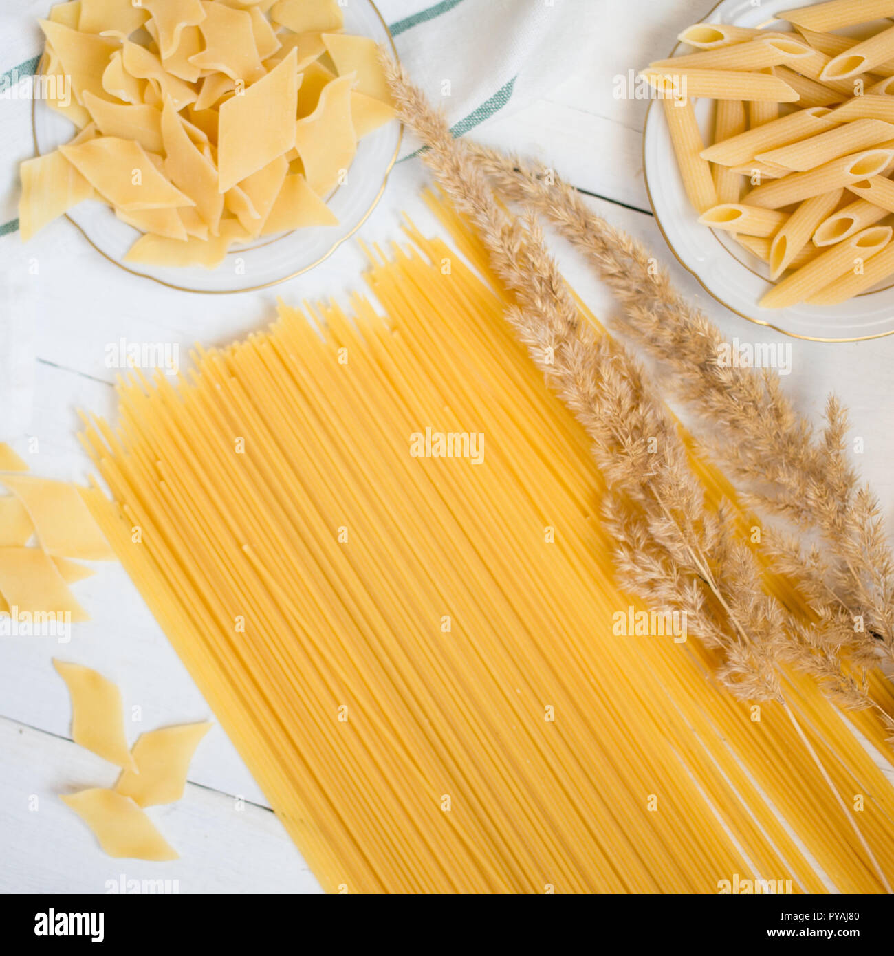 Variétés de pâtes sur une table en bois blanc, spaghetti, penne, maltagliati, la cuisine locale Banque D'Images