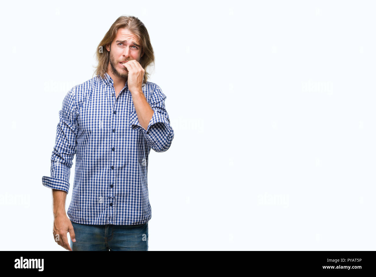 Jeune homme séduisant aux cheveux longs sur fond isolé à souligné et nerveux avec les mains sur la bouche de mordre les ongles. Problème d'anxiété. Banque D'Images