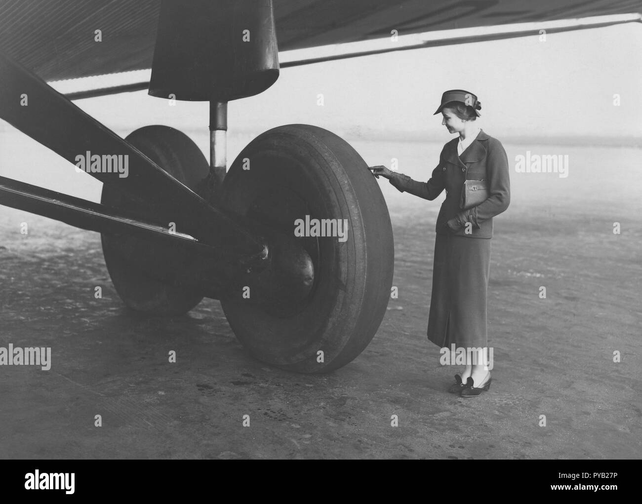 Avion dans les années 1930. Une jeune femme a l'air bien habillé petit lorsque l'on compare sa taille à l'roues géantes sur le train d'atterrissage à cet avion Junker allemand G38. Il a été utilisé entre Berlin et Londres du 1 juillet 1931 et était à l'époque le plus grand moteur de quatre avions de transport de passagers, avec 34 passagers et sept membres d'équipage. Banque D'Images