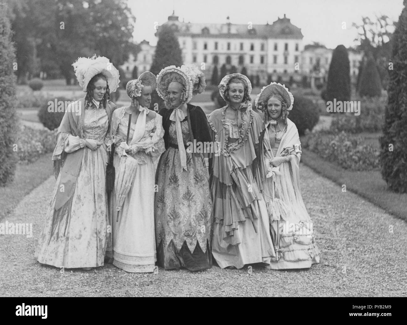 Bonnets Poke. Un groupe de cinq jeunes femmes dans le parc du château, Drottning holm pendant le tournage du film Filmen om Emelie Högqvist 1939. Ils sont tous habillés en femmes de l'année 1835. En particulier les chapeaux qui sont appelés Poke bonnet qui est entré en mode au début du 19ème siècle. Banque D'Images