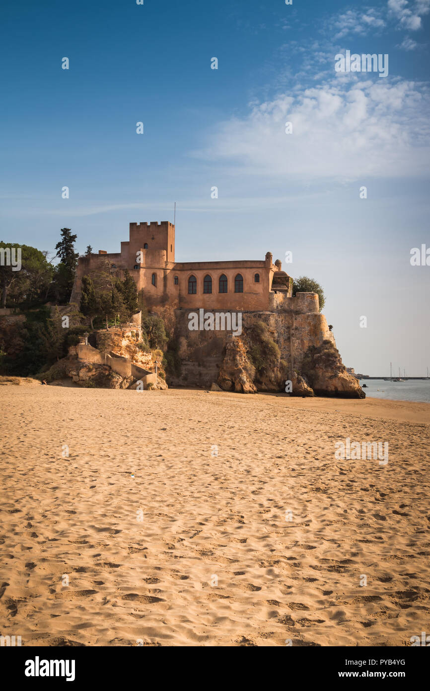 Château de São João do Arade sur un rocher sur la plage de sable. Automne ensoleillé avec ciel bleu et quelques nuages. Portimao, Algarve, Portugal. Banque D'Images