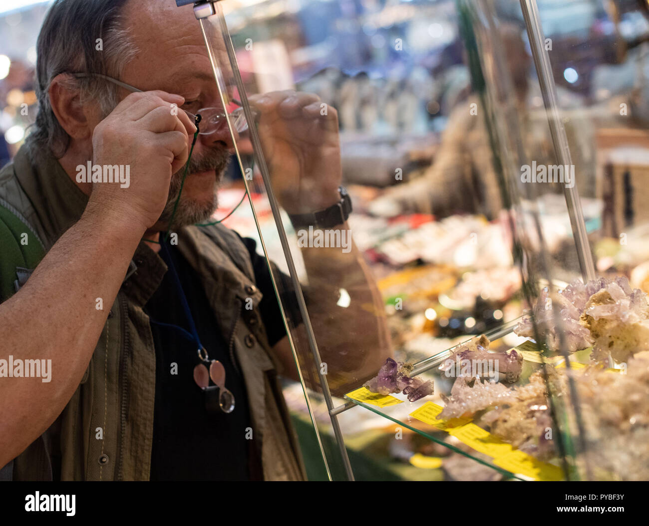 Munich, Allemagne. 26Th Oct, 2018. 26 octobre 2018, Allemagne, Munich : Frank Morgenstern, collectionneurs de minéraux, examine divers morceaux d'Améthyste à une table du concessionnaire lors de la minéral jours. Le Minéral jours sont une foire commerciale pour les minéraux, fossiles et pierres précieuses qui dure jusqu'à 28.10. Credit : Lino Mirgeler/dpa/Alamy Live News Banque D'Images