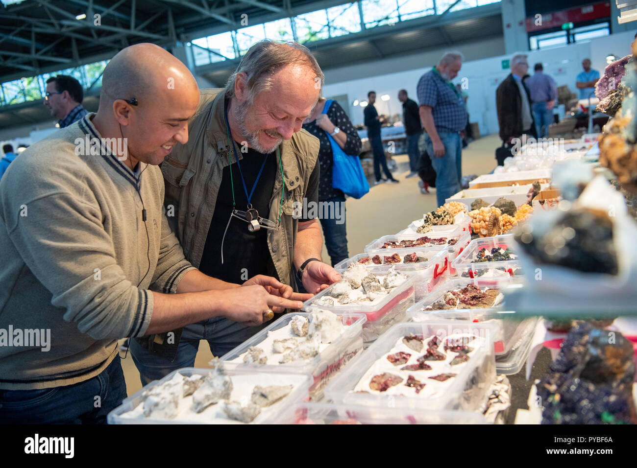 Munich, Allemagne. 26Th Oct, 2018. 26 octobre 2018, Allemagne, Munich : Frank Morgenstern (C), de collectionneurs de minéraux, est conseillé par un concessionnaire à un tableau du concessionnaire sur le minéral jours. Le Minéral jours sont une foire commerciale pour les minéraux, fossiles et pierres précieuses qui dure jusqu'au 28 octobre. Credit : Lino Mirgeler/dpa/Alamy Live News Banque D'Images