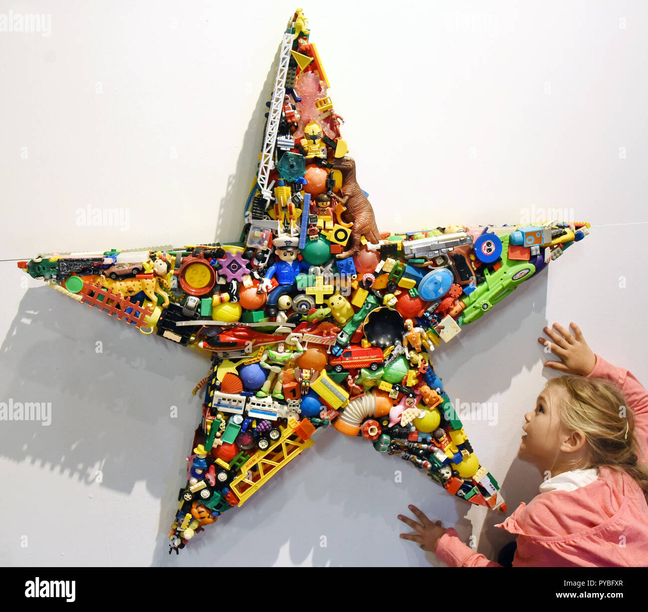 Leipzig, Allemagne. 25 octobre, 2018. 25 octobre 2018, l'Allemagne, Leipzig : une fille à l'upcycling juste 'Echt  Alt/ Original Old' à l'Kunstkraftwerk est à la recherche d'un star fait des jouets par designer sud-coréen Kim Yong Chul. 16 studios de design à partir de l'Allemagne, l'Italie, la Colombie, l'Espagne et la Hongrie sera exposant leurs produits inhabituels faits de matériaux de recyclage à la foire, qui a lieu en association avec les designers 'plume (26.10.-28.10.2018). Credit : Waltraud Grubitzsch/dpa-Zentralbild/ZB/dpa/Alamy Live News Banque D'Images