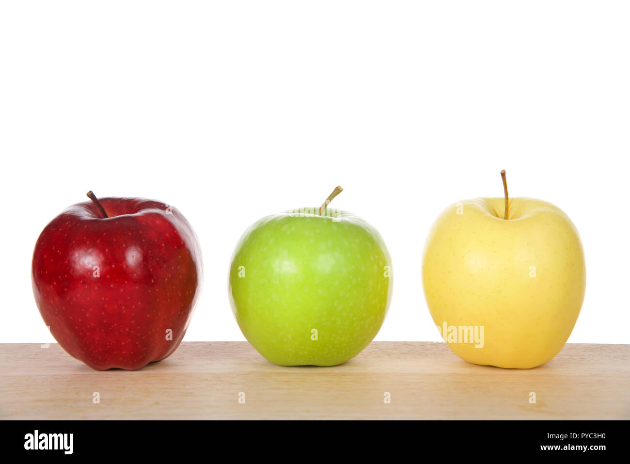 L'un rouge, vert et jaune pommes sur une table en bois isolé sur fond blanc Banque D'Images