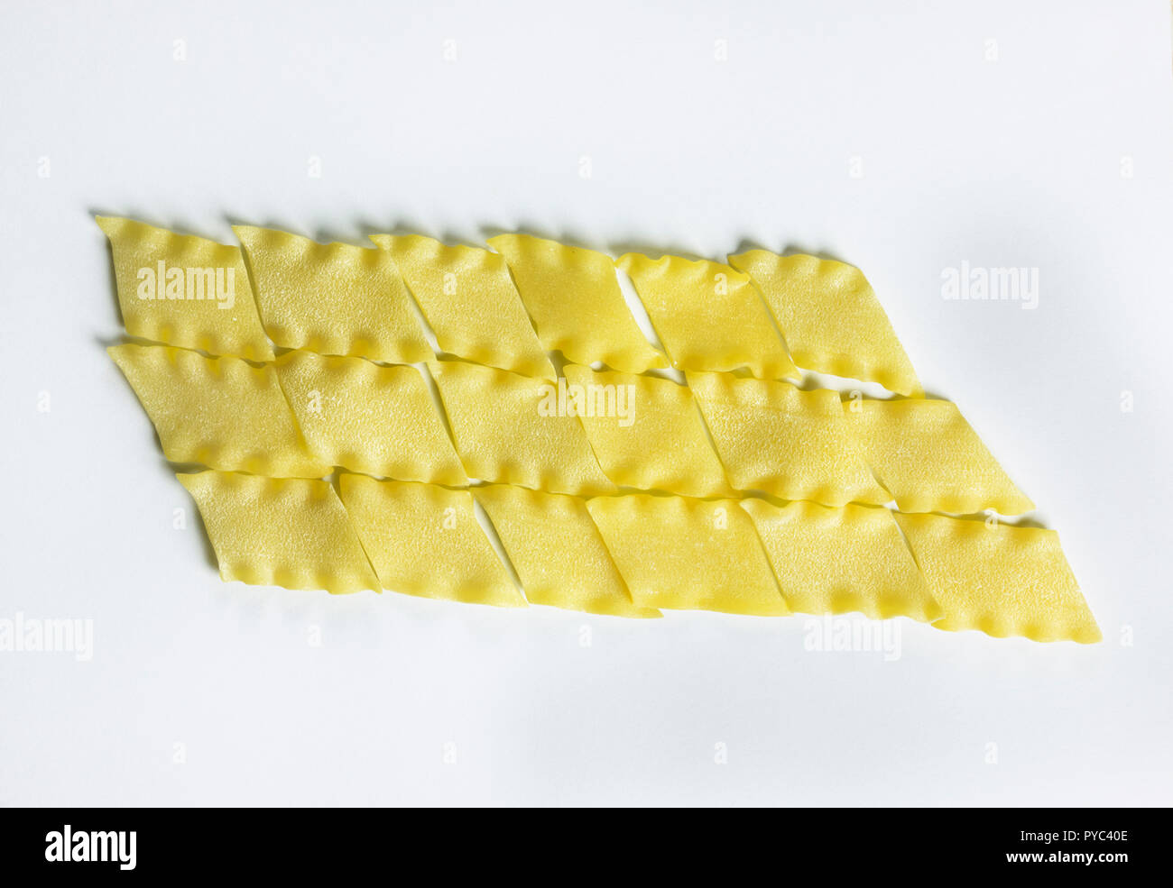Les pâtes italiennes à sec appelé pantacce sur fond blanc ,pâtes en forme de losange -avec contour ondulé ,drôle , composition studio shot , vue d'en haut Banque D'Images