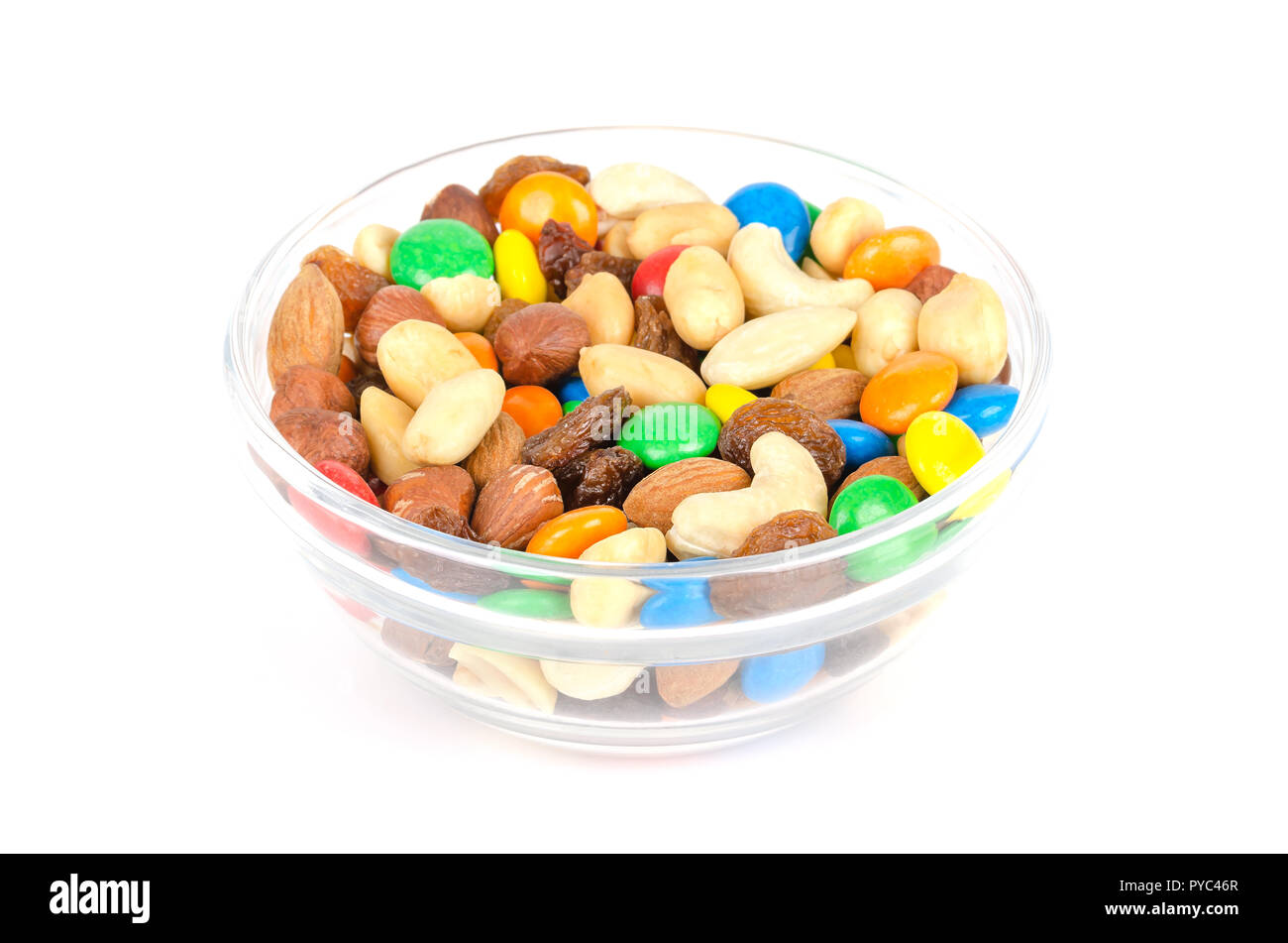 Mélange de traînée dans la cuvette en verre. Snack-mix. Amandes, Noix de cajou, les cacahuètes, les noisettes, les raisins secs et colorés au chocolat. La nourriture d'être prises le long de la randonnée. Banque D'Images