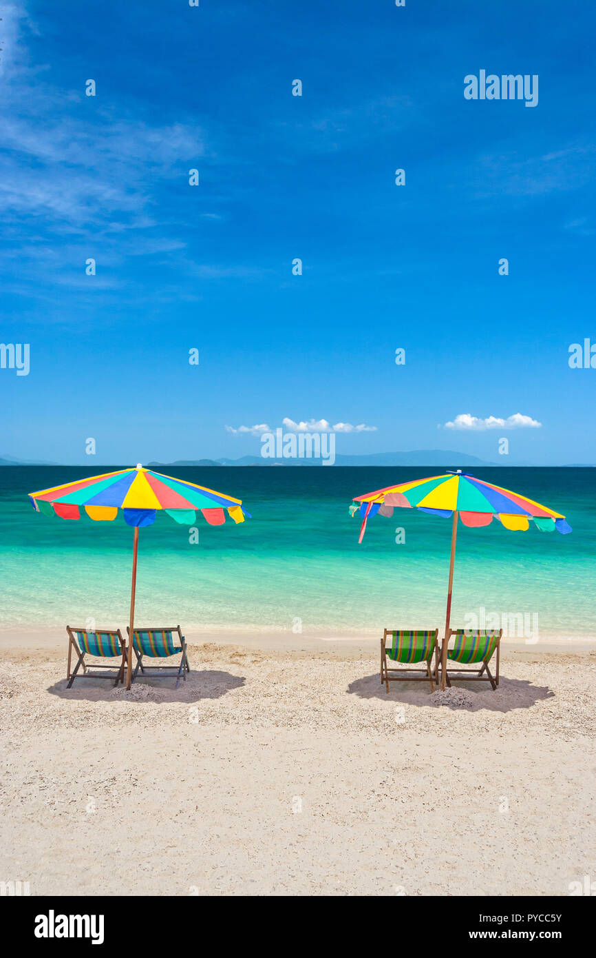 Chaises de plage avec parasols colorés sur une journée ensoleillée Banque D'Images