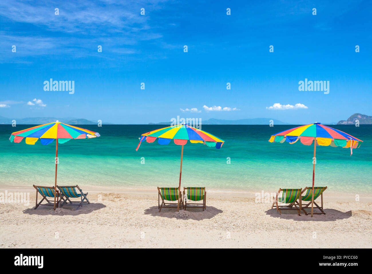 Chaises de plage avec parasols colorés sur une journée ensoleillée Banque D'Images