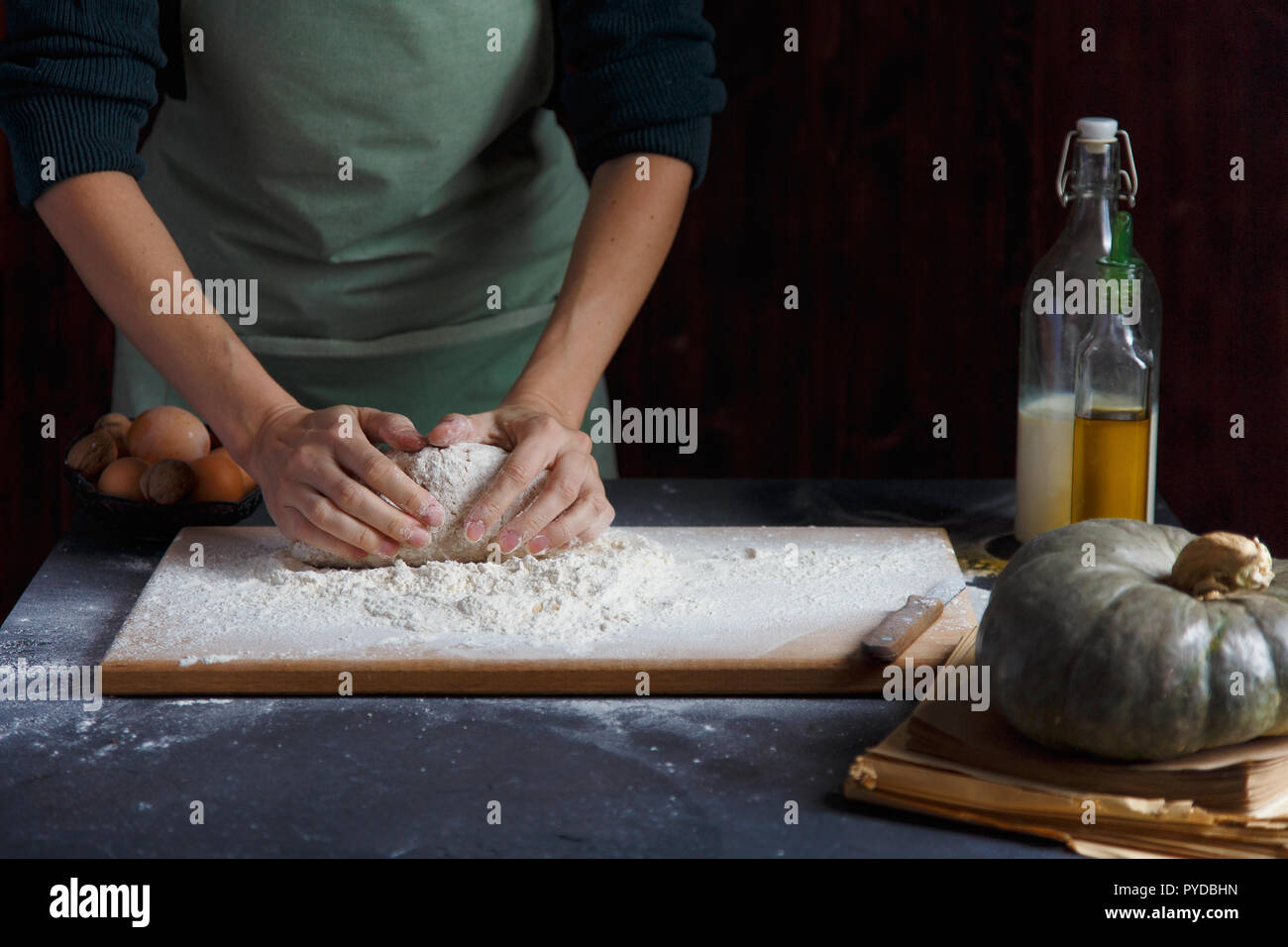Women's Hands pétrir la pâte. Ingrédients de cuisson sur table en bois Farine de l'huile de lait de citrouille Copy space Banque D'Images