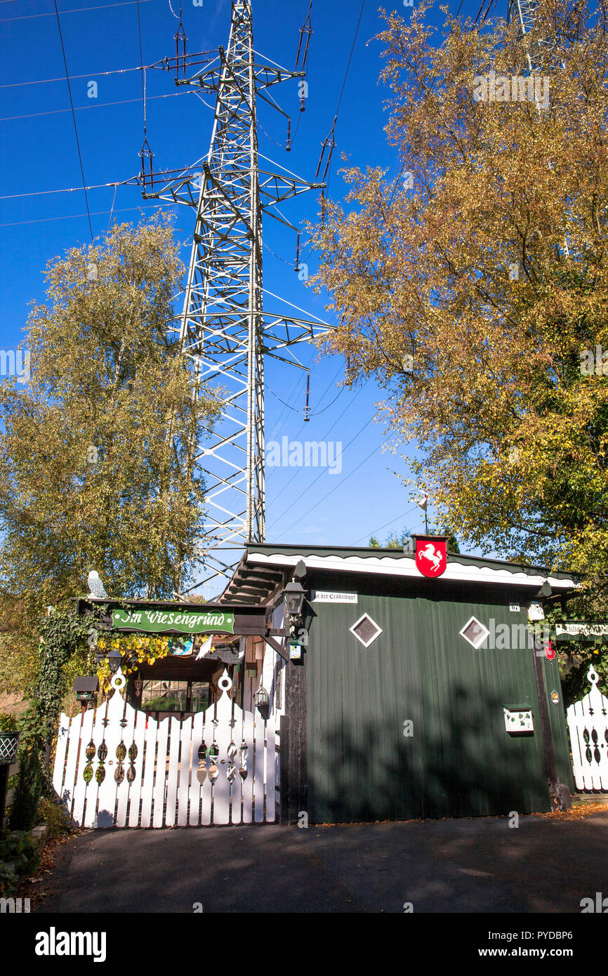 Cabane d'attribution en vertu d'un pylône haute tension à Herdecke, Allemagne. Schrebergarten-Haeuschen unter einem Hochspannungsmast à Herdecke, Deutschland. Banque D'Images