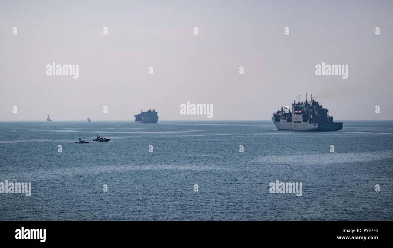 181022-N-UX013-1017 DÉTROIT D'ORMUZ (oct. 22, 2018) les petits bateaux iraniens se positionner à côté d'un convoi de la marine américaine la traversée du détroit d'Ormuz qui comprend la reconstitution de la flotte oiler USNS Henry J. Kaiser (T-AO-187), à droite, de la plate-forme mobile expéditionnaire USS Lewis B. Extracteur (ESB 3), au centre, à droite, l'océan-surveillance ship USNS Invincible (T-AGM-24), centre gauche, et destroyers lance-missiles USS DECATUR (DDG 73), à gauche, et l'USS Jason Dunham (DDG109). Les navires de la marine américaine sont déployés dans le domaine de la 5e flotte américaine des opérations à l'appui des opérations navales pour assurer stabil maritime Banque D'Images