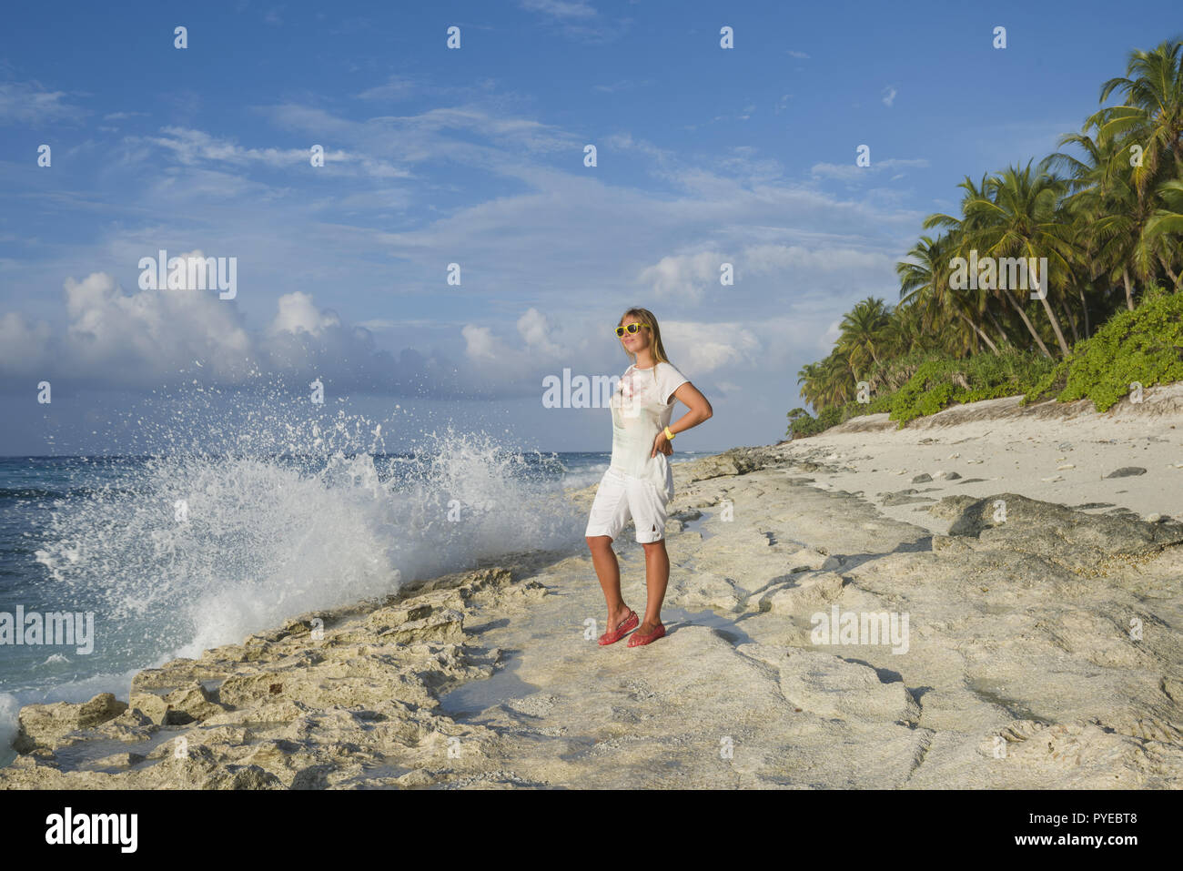 Jeune femme en tenue d'été l'article sur une plage, et à la recherche à l'horizon sur une île tropical exotique Banque D'Images