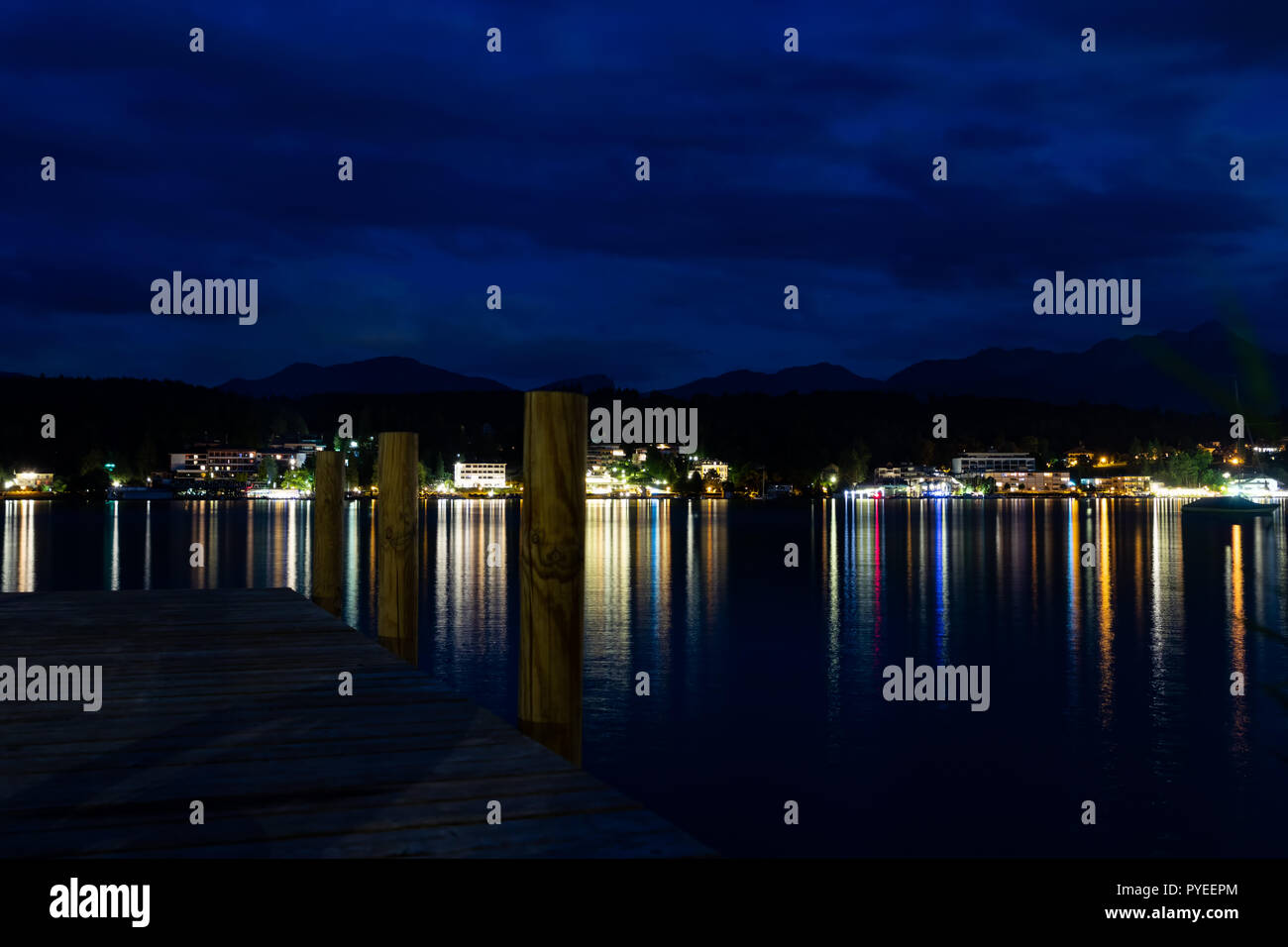 Nuages colorés sur le lac avec un quai au milieu et reflet dans l'eau. Capturé le Wörthersee, Roma, en Autriche. Banque D'Images