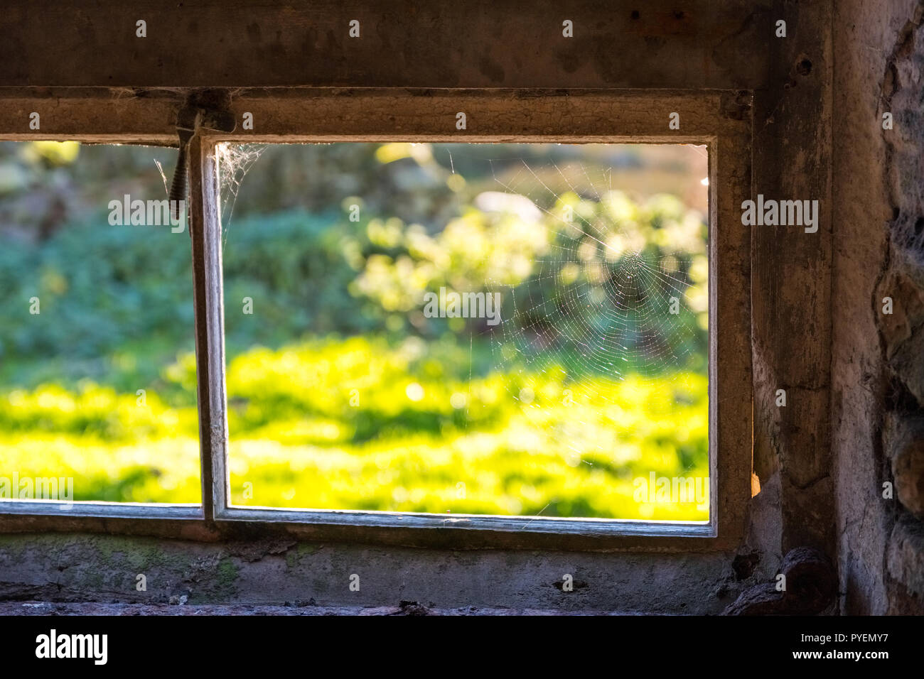 Fenêtre d'une ancienne grange en pierre avec araignée Banque D'Images