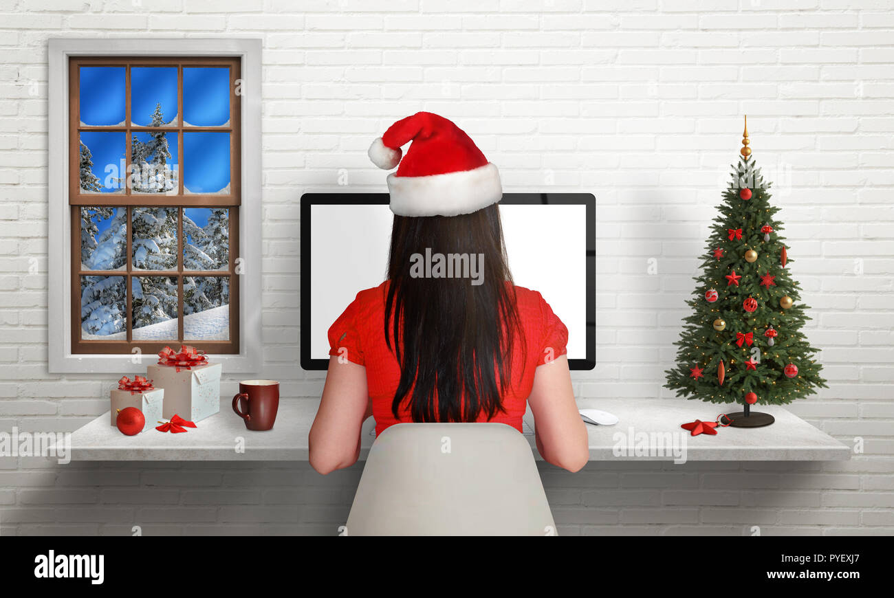 Fille travailler sur ordinateur durant les vacances de Noël dans son bureau entouré de décorations de Noël. Vue depuis l'arrière. Banque D'Images