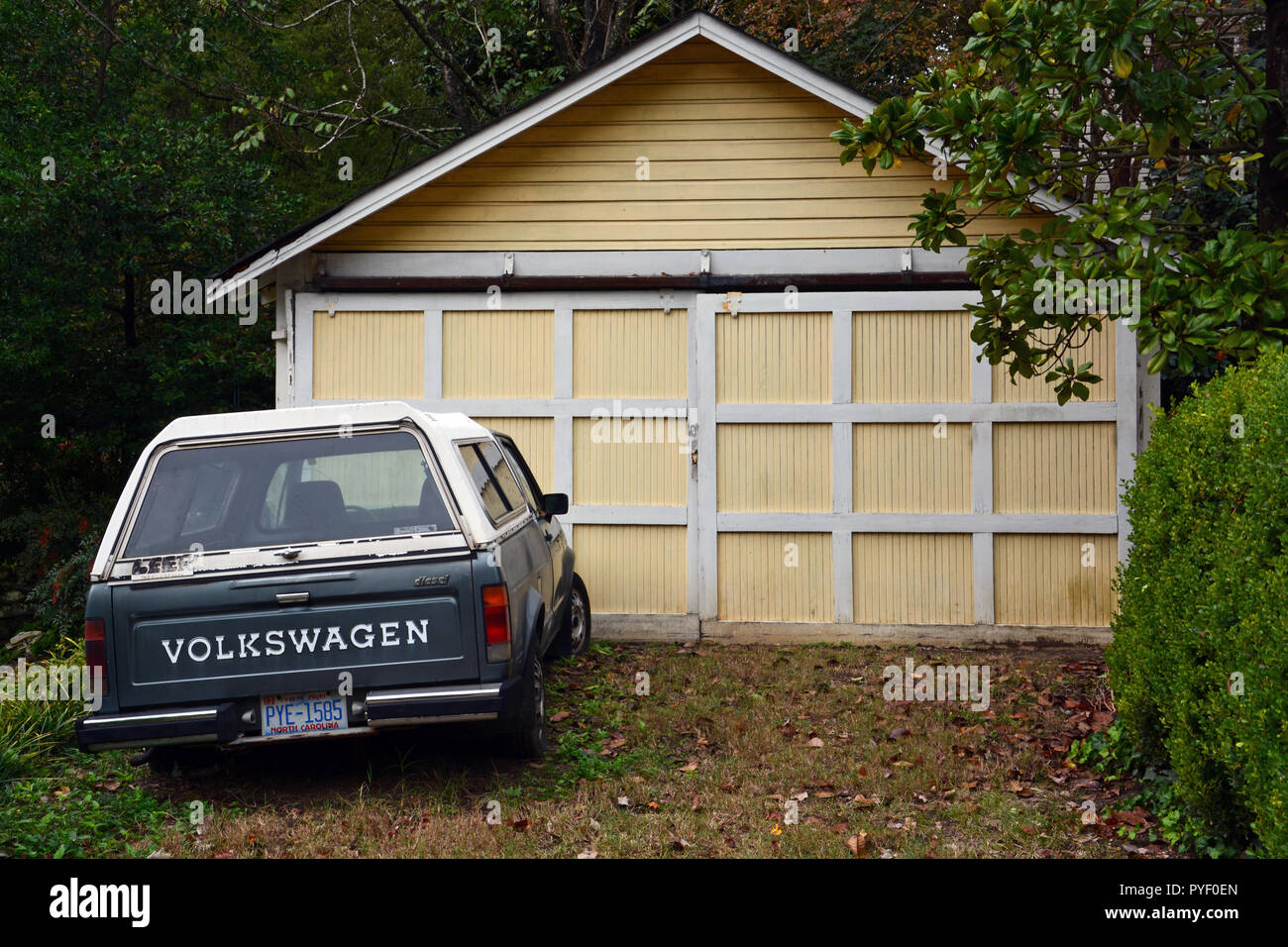 Une vieille camionnette Volkswagen bleue garée à l'extérieur d'un garage. Banque D'Images