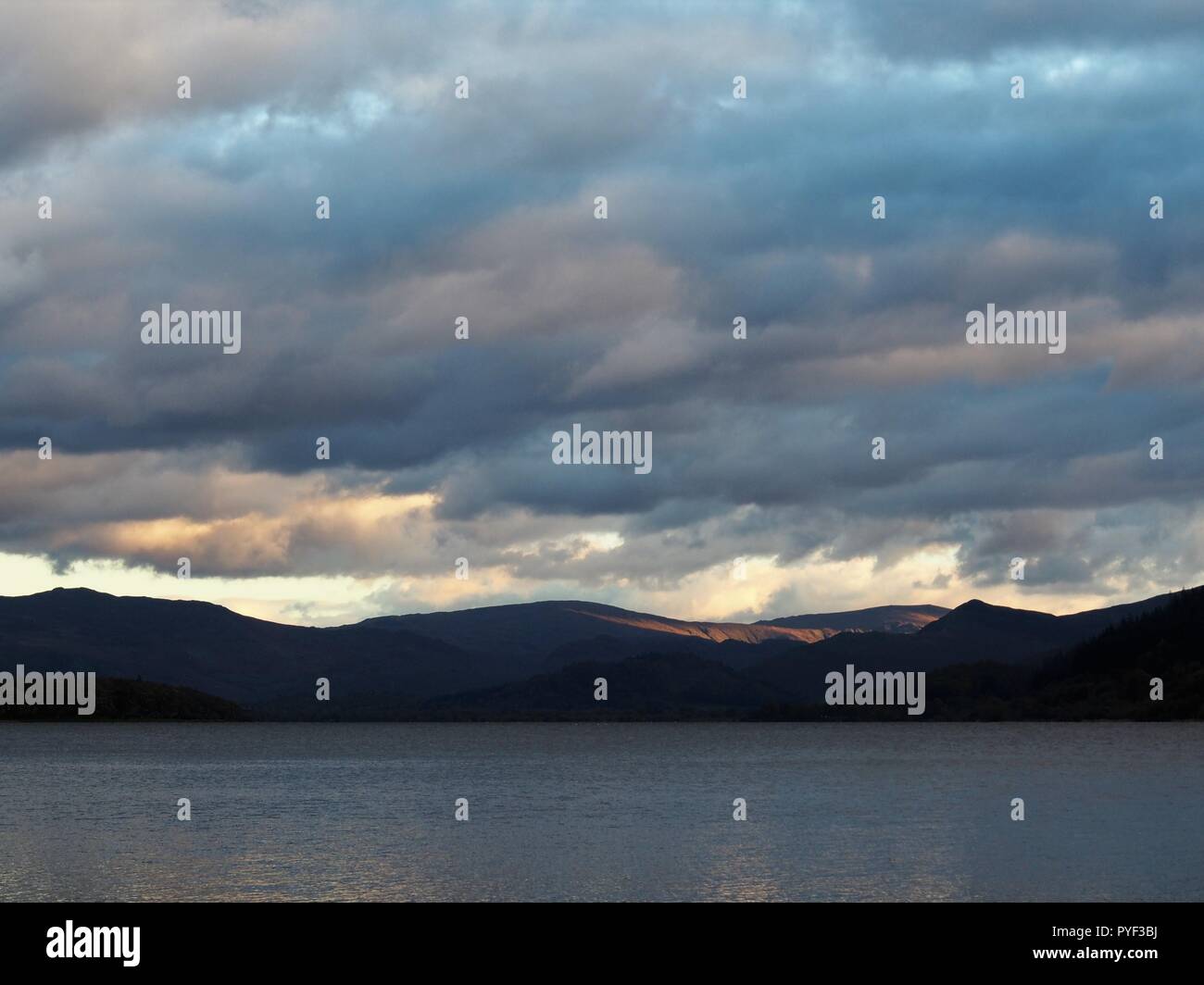 Coucher de soleil le Helvelyn d'éclairage vont de Bassenthwaite Lake, Parc National de Lake District, Cumbria, Angleterre, Royaume-Uni Banque D'Images