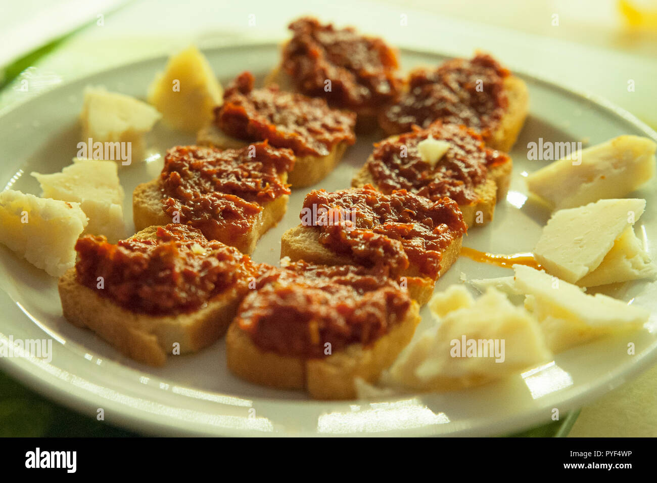 Sélection de tapas fromage Manchego et petits toasts avec du poivre rouge et sécher la pâte de tomate sur une assiette, un plat traditionnel espagnol ou Méditerranéen Banque D'Images