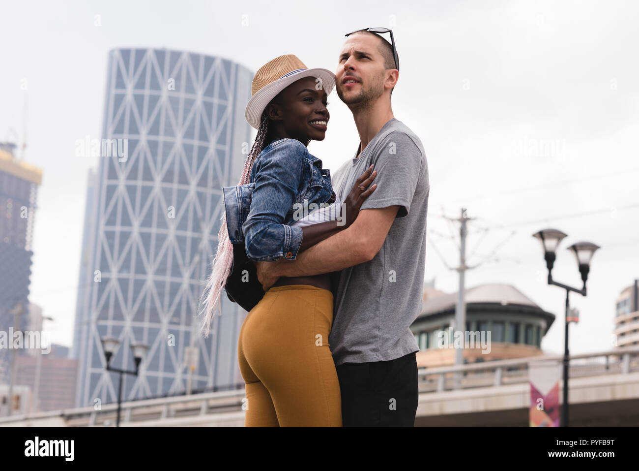 Smiling couple embracing contre le bâtiment Banque D'Images