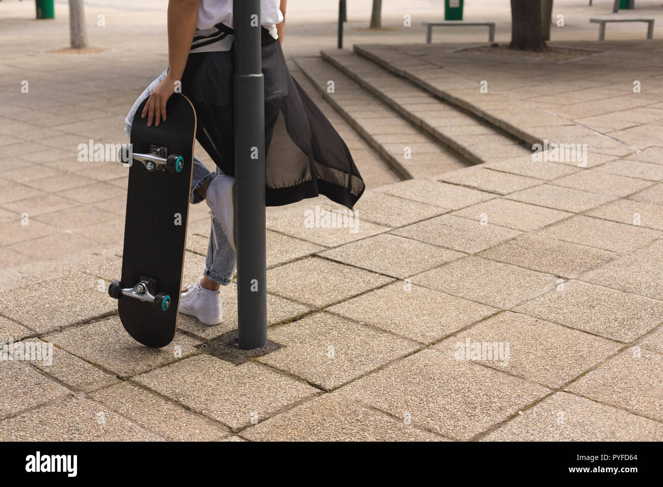 Femme debout avec la planche à roulettes Banque D'Images