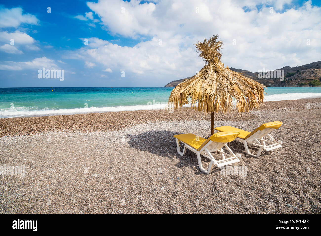 Chaises longues et parasol sur vide Vlycha beach près de Lindos Village (Rhodes, Grèce) Banque D'Images