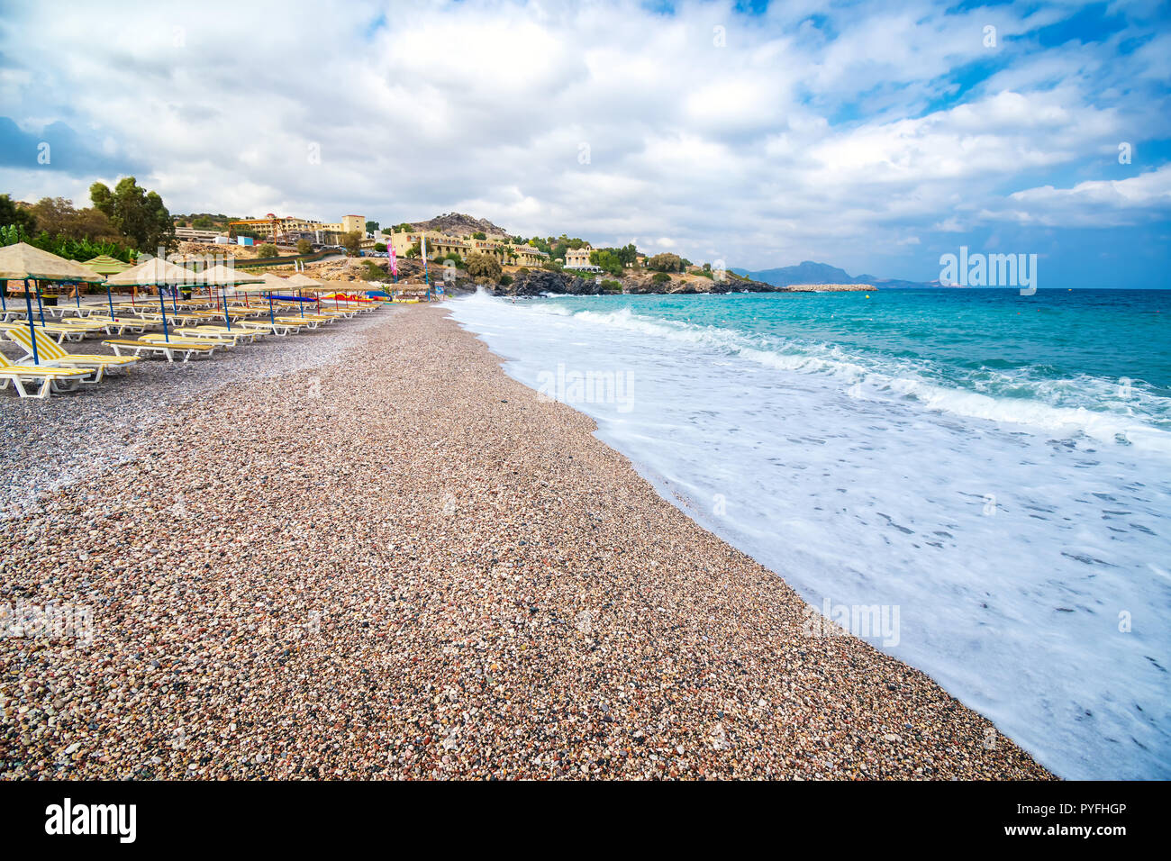 Des chaises longues et des parasols sur la plage de Vlycha près de hotel resort (Rhodes, Grèce) Banque D'Images