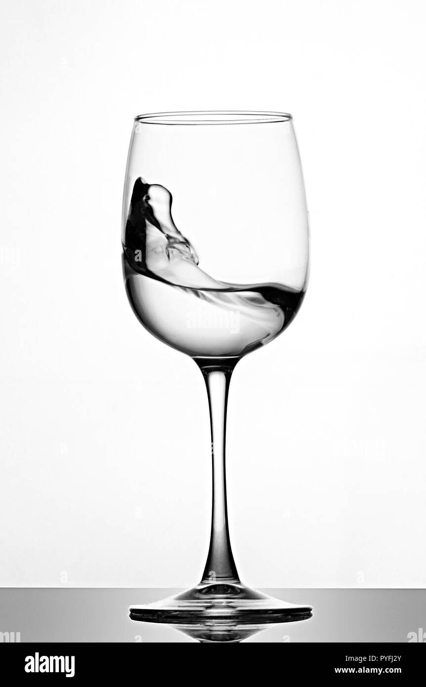 Une éclaboussure d'eau cristalline dans un verre de vin. Les projections d'eau. L'eau potable. L'alcool. Banque D'Images