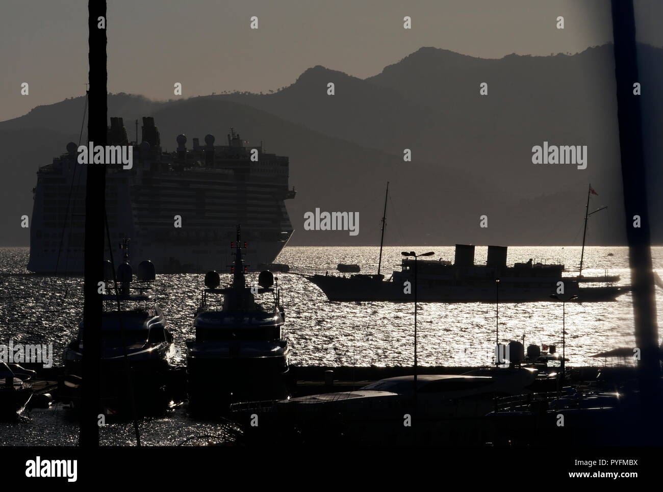 AJAXNETPHOTO. En 2018. CANNES, FRANCE. - Côte D'AZUR RESORT - À L'OUEST À TRAVERS LA BAIE DE CANNES AVEC LE BATEAU YACHT TALITHA ® et d'un paquebot de croisière norvégienne (L) ancrée dans les eaux ensoleillées CONTRE SILHOUTTE OF MOUNTAIN RANGE at sunset. PHOTO:JONATHAN EASTLAND/AJAX REF:180310 GX8  723 Banque D'Images