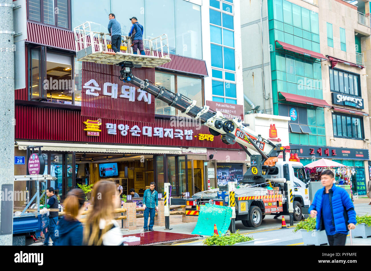 Ouvriers utilisent une grue pour soulever en position et de la région d'une nouvelle façade à l'extérieur d'un restaurant à Haeundae, Busa, la Corée du Sud. Banque D'Images