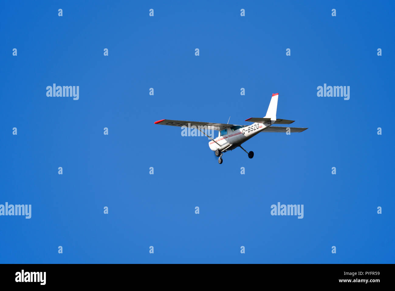 Avion léger Cessna 152 volant dans le ciel bleu. Avion d'aviation générale G-BSZO aéroporté en visibilité claire, vfr, règles de vol à vue Banque D'Images